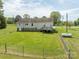 Spacious backyard with a lush lawn, wooden deck, and partially fenced perimeter for privacy at 1501 Nc Hwy 73 Hwy, Iron Station, NC 28080