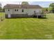 Expansive backyard with a well-maintained lawn, wooden deck, and partial stone foundation at 1501 Nc Hwy 73 Hwy, Iron Station, NC 28080