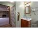 Bathroom with light green walls featuring vanity with mirror and a doorway to a room with a fireplace at 1501 Nc Hwy 73 Hwy, Iron Station, NC 28080