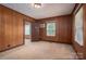 Bedroom featuring wood paneling, carpet, and a window for natural light at 1501 Nc Hwy 73 Hwy, Iron Station, NC 28080