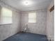 Cozy bedroom showcasing floral wallpaper, neutral carpet, and ample natural light from two windows at 1501 Nc Hwy 73 Hwy, Iron Station, NC 28080
