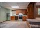 Basement kitchenette features upper and lower wood cabinets, black oven, and a window for natural light at 1501 Nc Hwy 73 Hwy, Iron Station, NC 28080