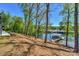 Picturesque backyard with mature trees leading down to the lake and a boat dock at 153 High Hills Dr, Mooresville, NC 28117
