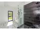 Modern bathroom featuring a glass-enclosed shower with unique black tiles and stylish fixtures at 153 High Hills Dr, Mooresville, NC 28117