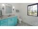 Bright bathroom featuring a blue vanity with marble countertop, chrome faucet, and a modern toilet at 153 High Hills Dr, Mooresville, NC 28117