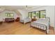 Spacious bedroom with hardwood floors, large windows, two beds, and a seating area at 153 High Hills Dr, Mooresville, NC 28117