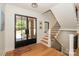 Bright foyer with hardwood floors, black framed glass front door and staircase with wooden treads at 153 High Hills Dr, Mooresville, NC 28117