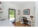 Bright home office featuring a desk, office chair, and an adjacent laundry area with a door leading to the outside at 153 High Hills Dr, Mooresville, NC 28117