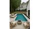 Beautiful pool area with lounge chairs, a fire pit, and meticulously landscaped surroundings at 153 High Hills Dr, Mooresville, NC 28117