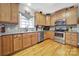 Cozy kitchen featuring wood cabinetry, modern stainless steel appliances, and hardwood flooring at 1589 Essex Hall Dr, Rock Hill, SC 29730