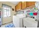 Bright laundry room with white washer and dryer, wash basin, plenty of cabinets, and natural lighting at 1589 Essex Hall Dr, Rock Hill, SC 29730