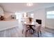 Well-lit dining area featuring a brick fireplace, updated flooring, and access to the kitchen at 163 Briarcliff Dr, Kannapolis, NC 28081