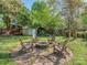 Landscaped backyard features a charming brick fire pit surrounded by wooden chairs at 1720 Chatham Ave, Charlotte, NC 28205
