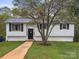 Charming home with a blooming tree, dark shutters, brick accents and a well-maintained lawn at 173 8Th Ave, Conover, NC 28613