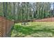 Fenced backyard features a charming fire pit area with Adirondack chairs, perfect for outdoor gatherings at 1900 Lakedell Dr, Charlotte, NC 28215