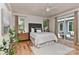 A relaxing main bedroom features hardwood floors, a ceiling fan, and natural light from surrounding windows at 1900 Lakedell Dr, Charlotte, NC 28215