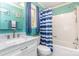 Updated bathroom features a white vanity, toilet, a shower-tub combination, and blue walls and curtains at 201 Olde Coach Ln, Crouse, NC 28033