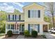 Charming two-story home with a welcoming front porch and beautiful, lush landscaping at 201 Olde Coach Ln, Crouse, NC 28033