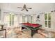 Spacious game room featuring a pool table, ceiling fan, and natural light from multiple windows at 201 Olde Coach Ln, Crouse, NC 28033
