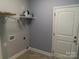 Practical laundry room with tile flooring, white shelving, and washer/dryer hookups at 2127 Cedar Rd, York, SC 29745