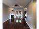 Open living room with a fireplace, dark wood floors, ceiling fan, and access to the back patio through French doors at 2127 Cedar Rd, York, SC 29745