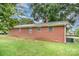 Rear exterior of a brick home surrounded by grass and mature trees at 2218 W Fifth Ave, Gastonia, NC 28052