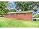 Brick home exterior showing grassy backyard, and mature shade trees at 2218 W Fifth Ave, Gastonia, NC 28052