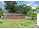 Backyard of a brick home showing lawn and the home's exterior at 2218 W Fifth Ave, Gastonia, NC 28052