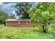 Brick home exterior showing grassy backyard and mature shade trees at 2218 W Fifth Ave, Gastonia, NC 28052