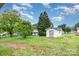 Backyard featuring grass, trees and exterior of small shed at 2218 W Fifth Ave, Gastonia, NC 28052