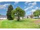 Exterior view of grassy backyard with RV and truck in driveway at 2218 W Fifth Ave, Gastonia, NC 28052