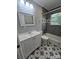 Well-lit bathroom with a stylish vanity, patterned floor tiles, and bathtub at 2218 W Fifth Ave, Gastonia, NC 28052