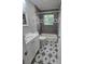 Bathroom features a white vanity, decorative tile floor, and tub with tiled walls at 2218 W Fifth Ave, Gastonia, NC 28052