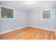 Bedroom showcasing hardwood floors, neutral walls, and natural light from two windows at 2218 W Fifth Ave, Gastonia, NC 28052