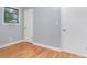 A bedroom featuring hardwood floors, neutral walls, one window and two white doors at 2218 W Fifth Ave, Gastonia, NC 28052