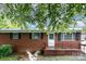 Attractive brick home featuring a covered front porch and well-manicured lawn at 2218 W Fifth Ave, Gastonia, NC 28052