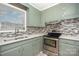 Charming kitchen with stainless steel appliances, mosaic backsplash, and green cabinetry at 2218 W Fifth Ave, Gastonia, NC 28052