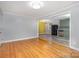 Open-concept living room showcasing hardwood floors and connection to adjacent kitchen at 2218 W Fifth Ave, Gastonia, NC 28052