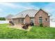 Large brick home with a patio area, manicured lawn, and fenced yard at 236 Riley Dr, Taylorsville, NC 28681