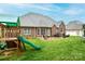 Spacious backyard with lush green grass, patio, and play set, perfect for outdoor activities at 236 Riley Dr, Taylorsville, NC 28681