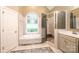Well-lit bathroom featuring a large soaking tub, a glass-enclosed shower, and neutral tile at 236 Riley Dr, Taylorsville, NC 28681