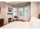 Bright main bedroom featuring a fireplace, hardwood floors, bay windows, and a cozy seating area at 236 Riley Dr, Taylorsville, NC 28681