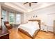 Spacious main bedroom with a tray ceiling, large windows, hardwood floors, and a seating area at 236 Riley Dr, Taylorsville, NC 28681