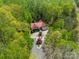 Aerial view of a beautiful home surrounded by lush green trees, circular drive, and red roof at 2599 Highway 557 None, Clover, SC 29710