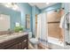 Well-lit bathroom with a tub-shower combo featuring neutral-toned tile, a single sink vanity and a light-blue colored wall at 2599 Highway 557 None, Clover, SC 29710
