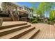 Multi-level wooden deck with stairs leading to a stone patio and outdoor fireplace create a serene outdoor oasis at 263 Fernbrook Dr, Mooresville, NC 28117