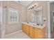 Well-lit bathroom features a double vanity, large mirror, wood cabinets, and a window with bright white shutters at 263 Fernbrook Dr, Mooresville, NC 28117