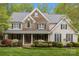 Charming two-story home featuring a stone facade, manicured landscaping and a welcoming front porch at 263 Fernbrook Dr, Mooresville, NC 28117
