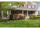 Charming home exterior featuring a cozy porch, lush landscaping, and stone and siding accents at 263 Fernbrook Dr, Mooresville, NC 28117
