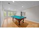 Basement game room featuring pool table, wood laminate flooring, and natural lighting at 263 Fernbrook Dr, Mooresville, NC 28117
